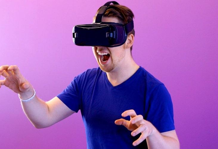 desktop intro section image of a man wearing vr headset, playing, with his arms up like hes about to attack